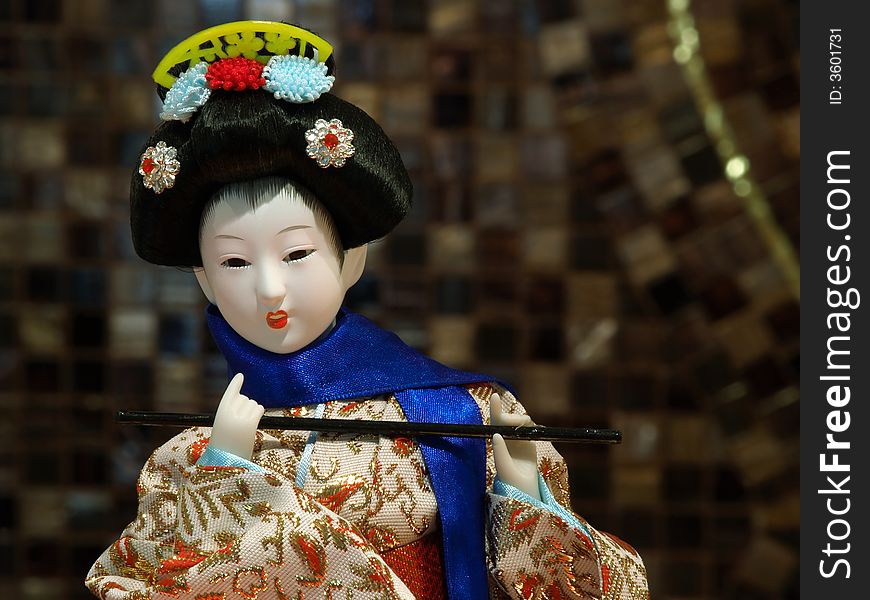 Traditional Japanese porcelain geisha doll wearing silk kimono