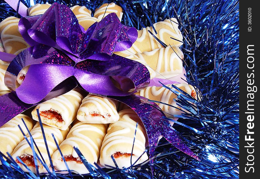 Close-up cookies with violet bow on the blue tinsel