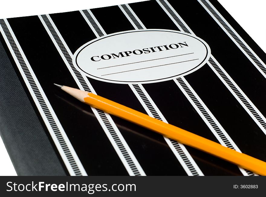 A black and white striped composition book and a yellow pencil on a white background, copy space on cover of notebook