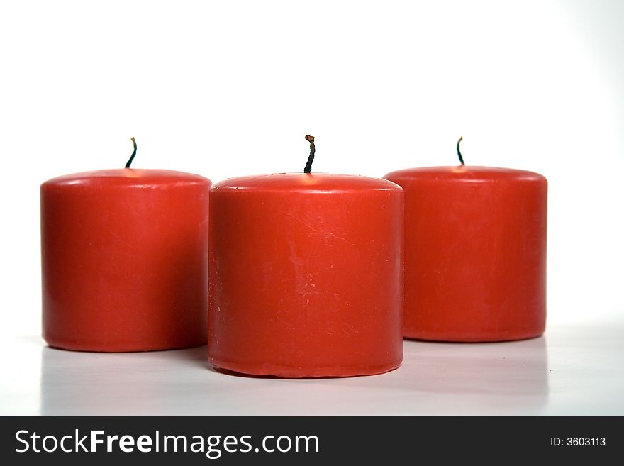 Three red christmas candles isolated on white