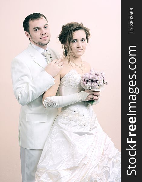 Young couple in wedding wear with bouquet of chrysanthemum. Special pink toned photo f/x