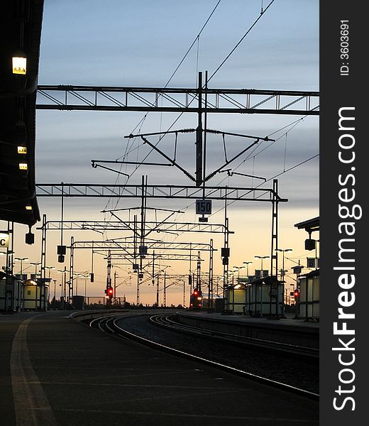 Railroad station in the morning with train far away.