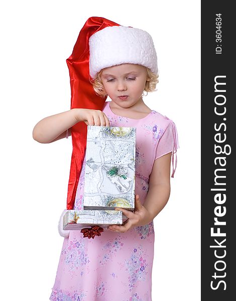 Cute fair-haired girl in Santa's hat getting out present  from the box. Cute fair-haired girl in Santa's hat getting out present  from the box