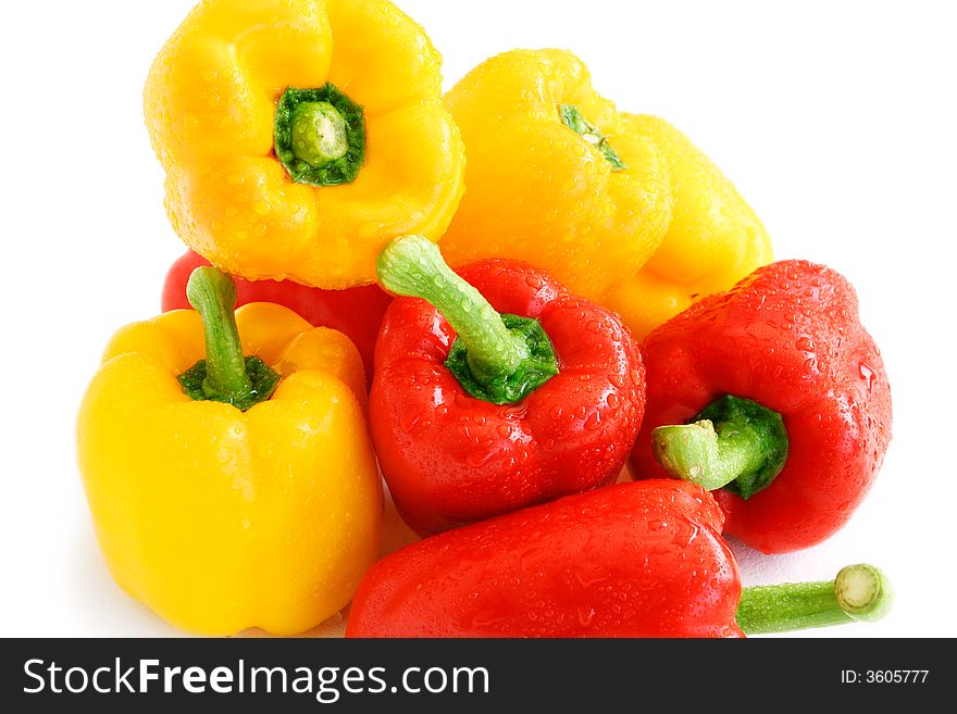 Pile of red and yellow paprikas in shiny water droplets