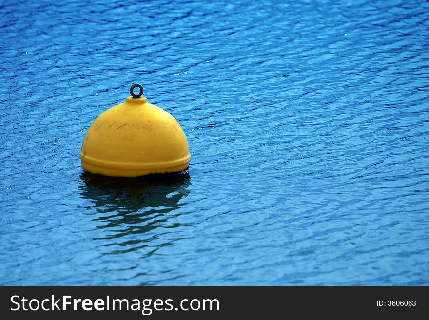 Yellow buoy on blue sea surface