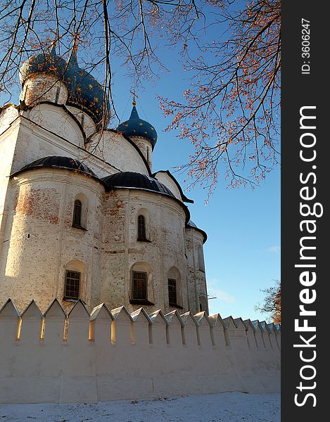 The old russian cathedral with branches of trees and blue sky