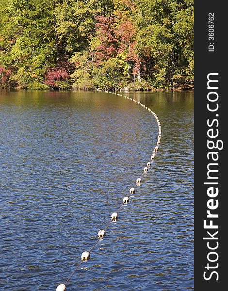 A divider of floats crossing a blue lake. A divider of floats crossing a blue lake