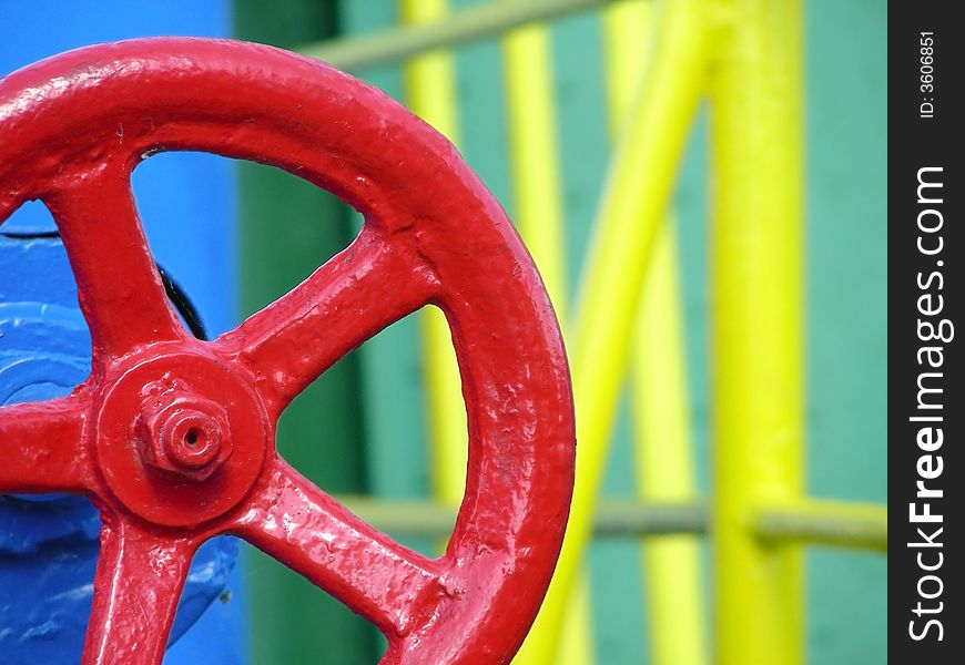 Red big valve of a ship with colorful background