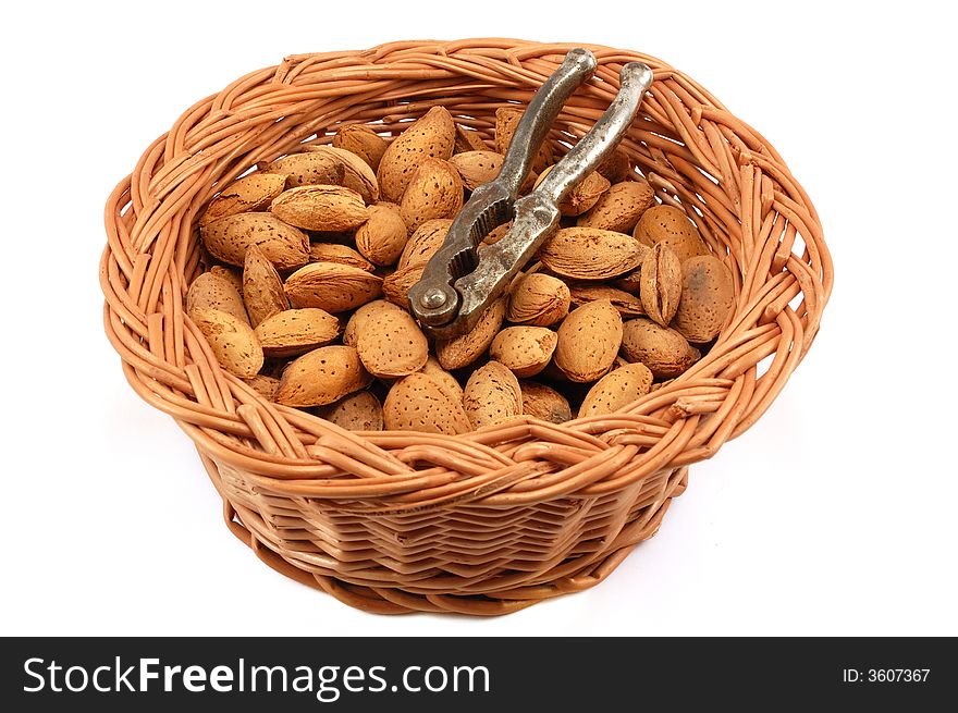 Whole almonds with nutcracker in a basket against white background. Whole almonds with nutcracker in a basket against white background.
