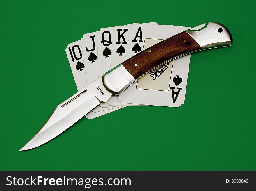 Playing cards and knife isolated over green background. Playing cards and knife isolated over green background