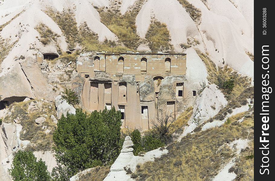 In ancient times people carved out homes in the fairy chimney rock formations in Cappadocia, Turkey. The houses are a popular tourist attraction for people on vacation or holiday. In ancient times people carved out homes in the fairy chimney rock formations in Cappadocia, Turkey. The houses are a popular tourist attraction for people on vacation or holiday.