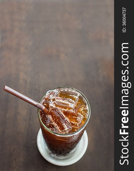 Iced black coffee on the wooden table in coffee cafe.