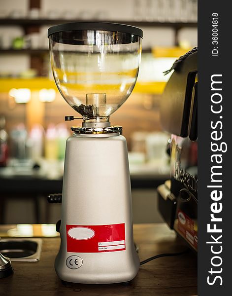 Coffee grinder on a wooden table in a coffee shop.