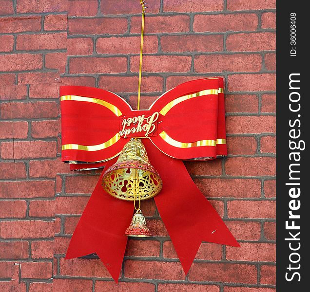 a golden christmas bell with red ribbon