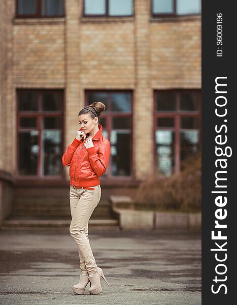 Beautiful woman in a red jacket posing on a big city background. Beautiful woman in a red jacket posing on a big city background