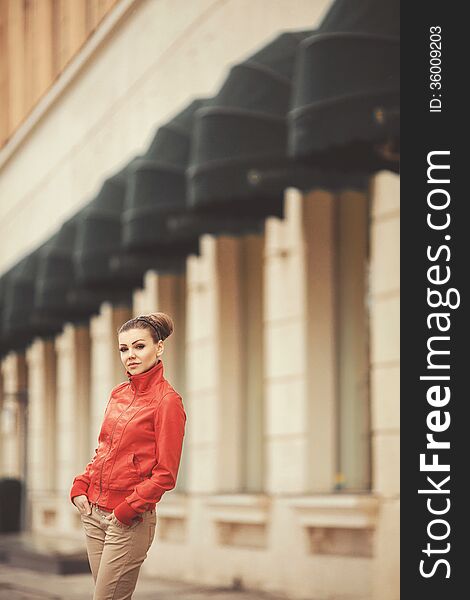 Beautiful woman in a red jacket posing on a big city background. Beautiful woman in a red jacket posing on a big city background