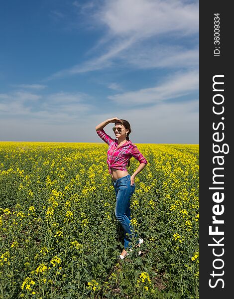 Young beautiful woman in flowering field in summer. Outdoors