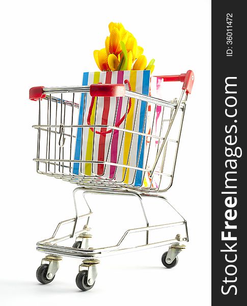 A shopping cart with gift bag filled with flowers. A shopping cart with gift bag filled with flowers