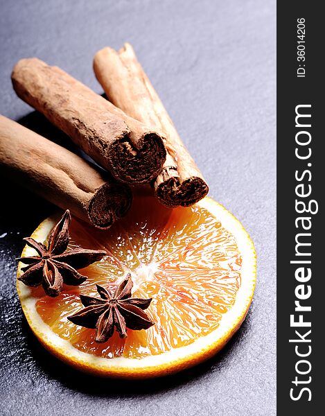 Composition of Orange slice with Cinnamon, star anise on black background. Composition of Orange slice with Cinnamon, star anise on black background