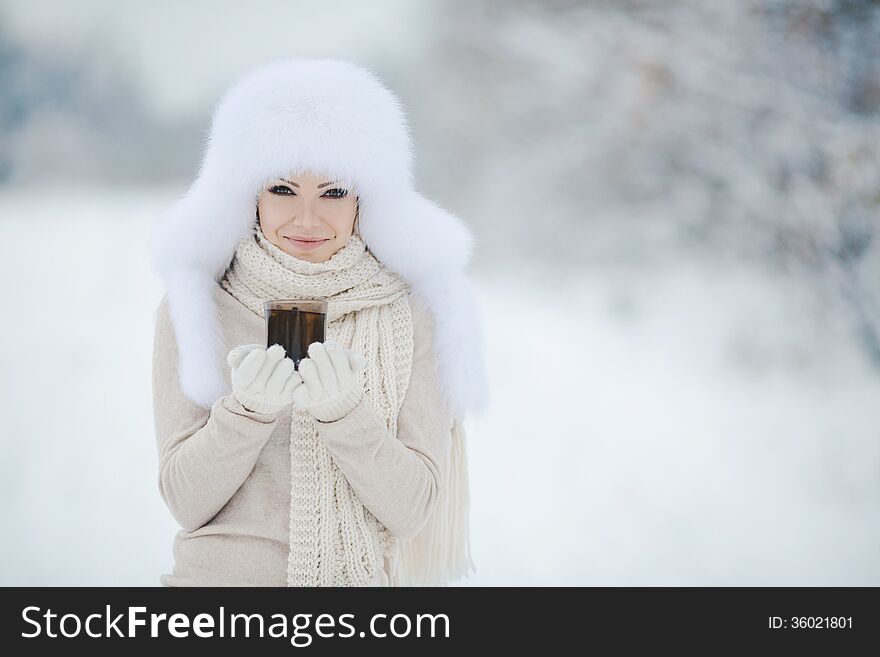 Winter Portrait Of Beautiful Smiling Woman With Snowflakes In White Furs