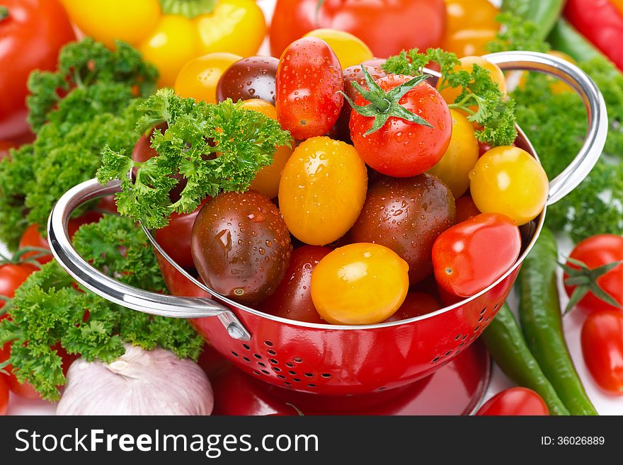 Assorted cherry tomatoes in a colander, garlic, spices and herbs