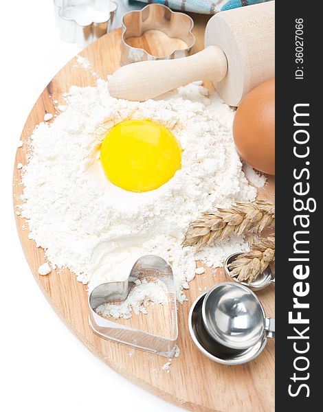 Baking ingredients - flour, egg, measuring spoons and baking forms, isolated on white. Baking ingredients - flour, egg, measuring spoons and baking forms, isolated on white