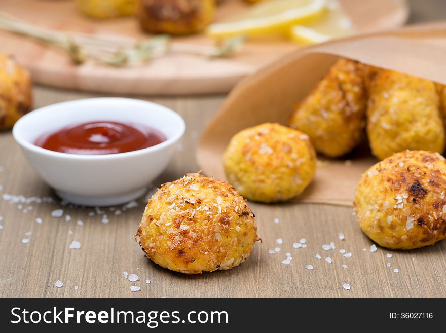 Chicken meatballs with tomato sauce on a wooden table, close-up, horizontal