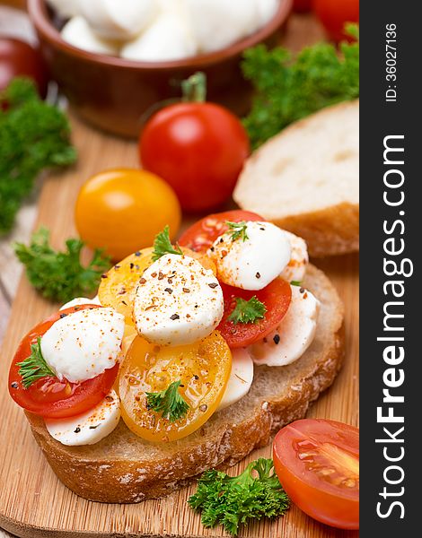 Ciabatta with mozzarella and colorful cherry tomatoes, close-up, vertical