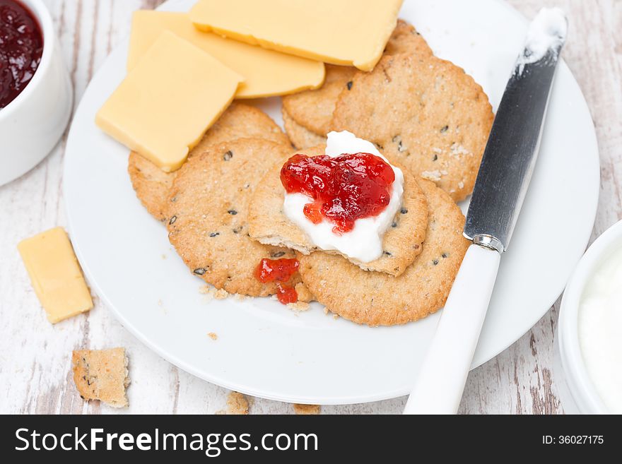 Crackers with cream cheese and berry jam for breakfast, close-up