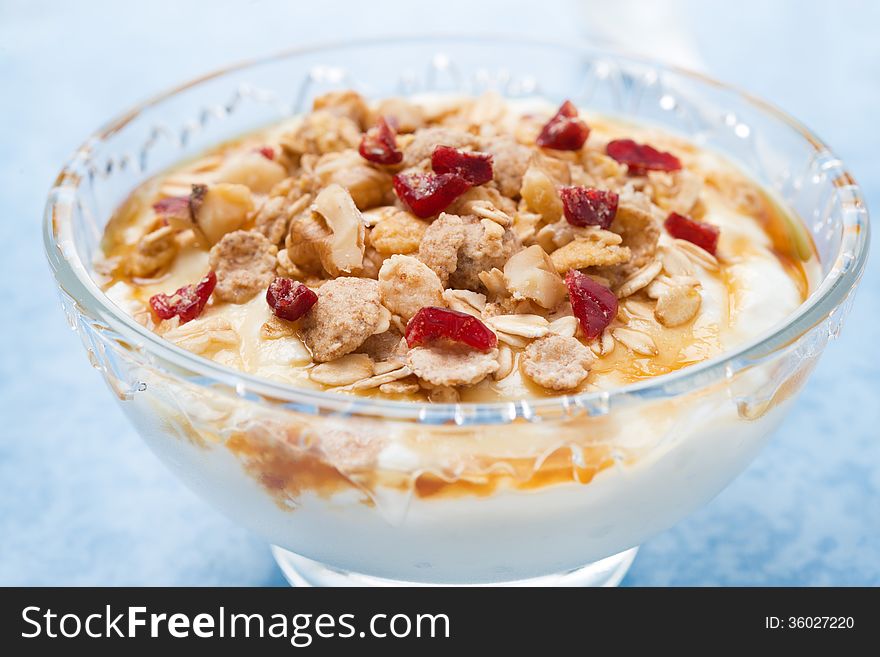 Dessert of natural yogurt with maple syrup, granola and nuts, close-up, horizontal