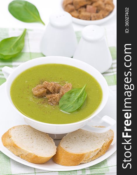 Spinach soup with croutons in a bowl, close-up