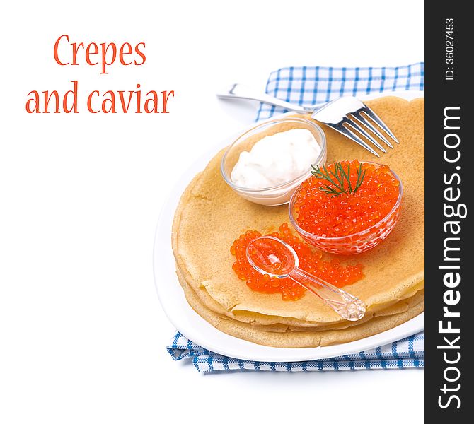 Traditional crepes with red caviar and sour cream on the plate, isolated on white