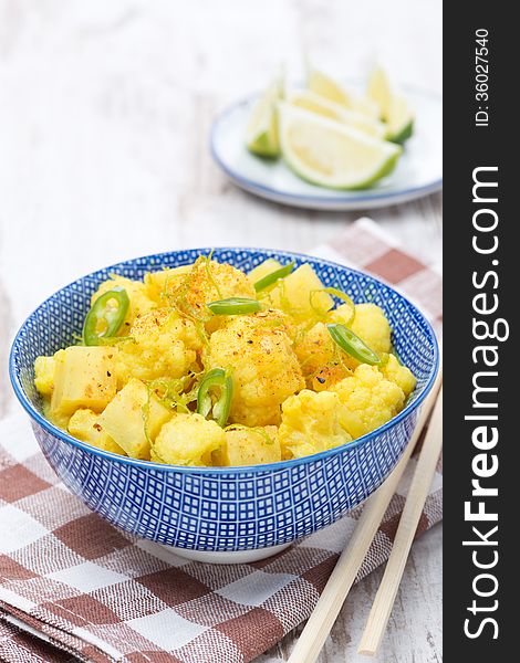 Vegetable curry with lime, chilli and mint in a bowl, vertical