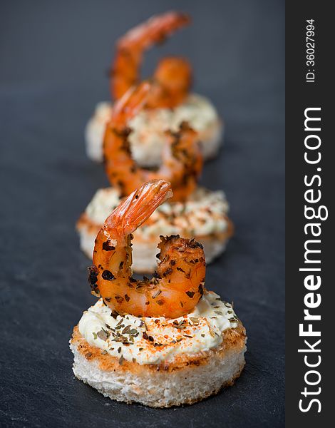 Appetizer with spicy shrimps on toast, close-up