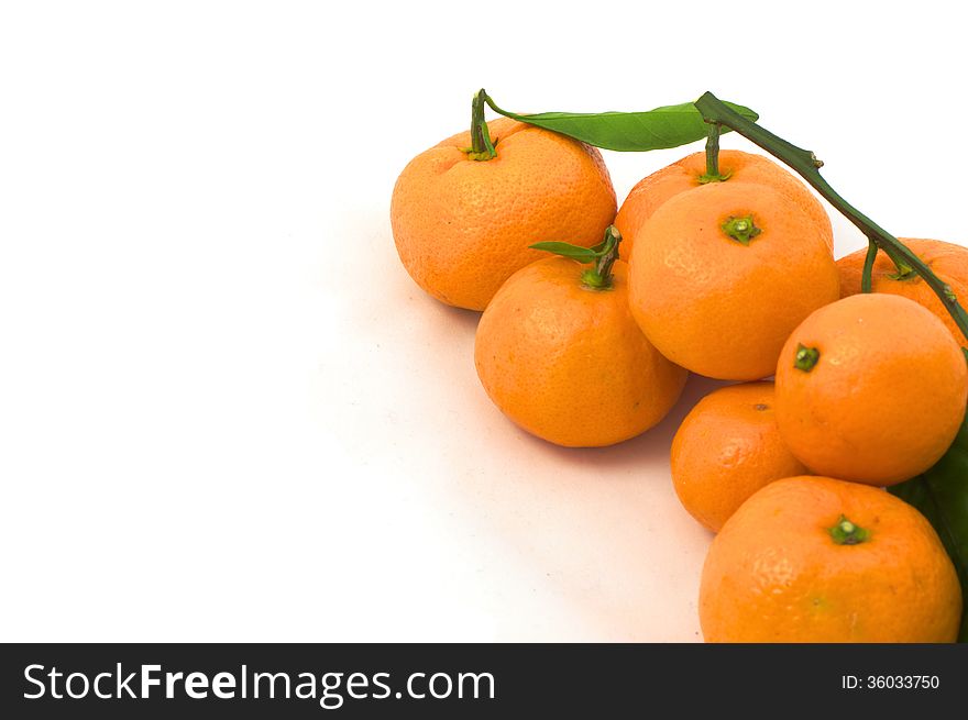 Tangerines with leaves in the lower right corner