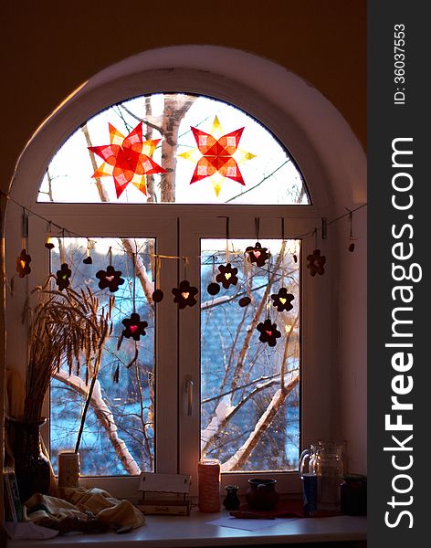 Window decorated with paper stars and a garland of gingerbread. Window decorated with paper stars and a garland of gingerbread