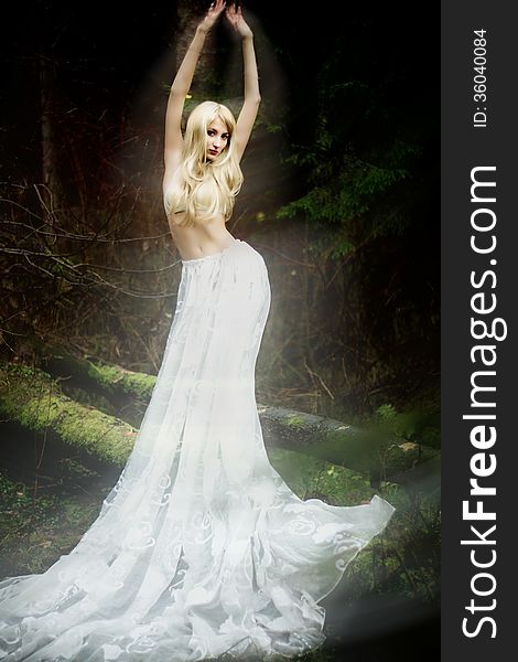 Blonde Bride Angel In Long White Skirt Standing In Dark Forest