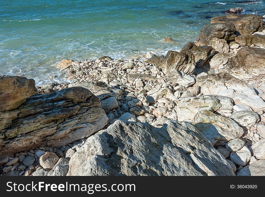 Ukraine, peninsula of Crimea, Sea coast on the Black Sea, large and small pebbles, large boulders, sea waves. Ukraine, peninsula of Crimea, Sea coast on the Black Sea, large and small pebbles, large boulders, sea waves