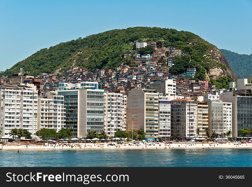 Luxury residential apartment and hotel buildings in the front of the Copacabana beach with mountains behind in Rio de Janeiro, Brazil. Luxury residential apartment and hotel buildings in the front of the Copacabana beach with mountains behind in Rio de Janeiro, Brazil.