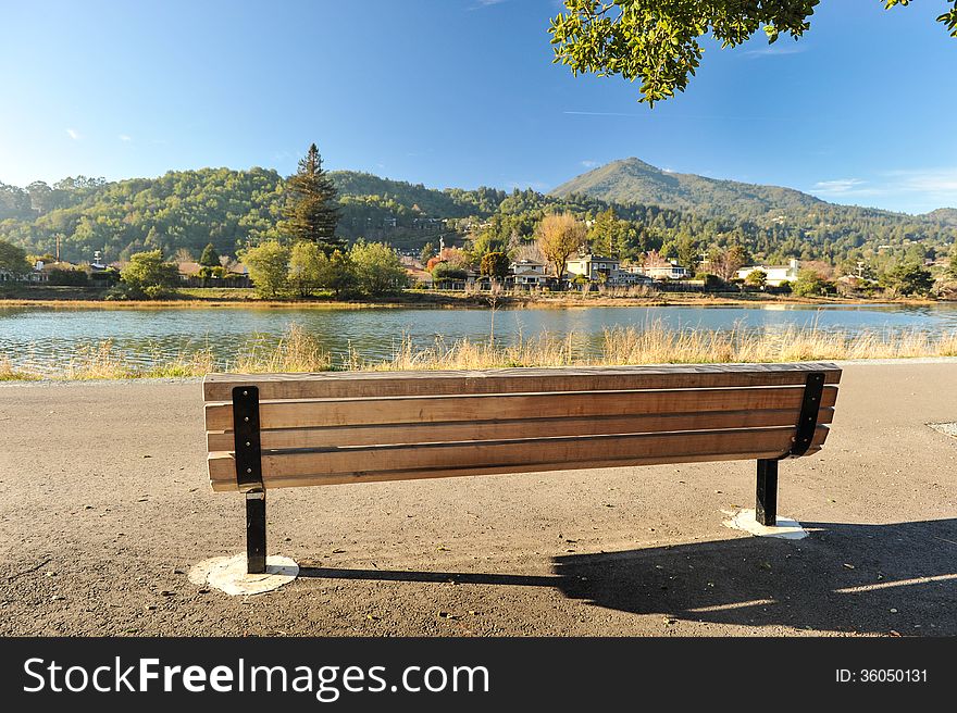 River with a wooden bench by it with background of a mountain. River with a wooden bench by it with background of a mountain
