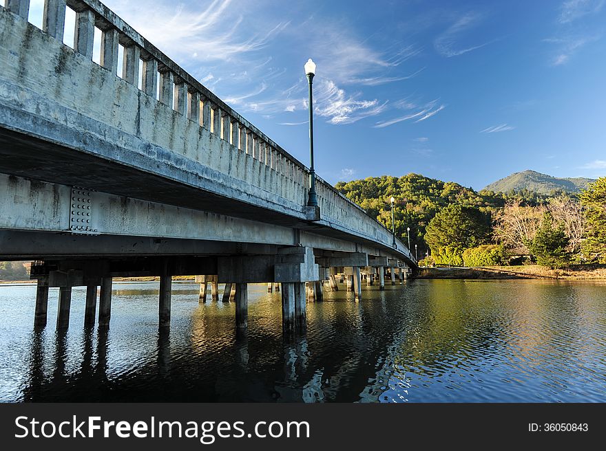 Concrete bridge with light pole over river