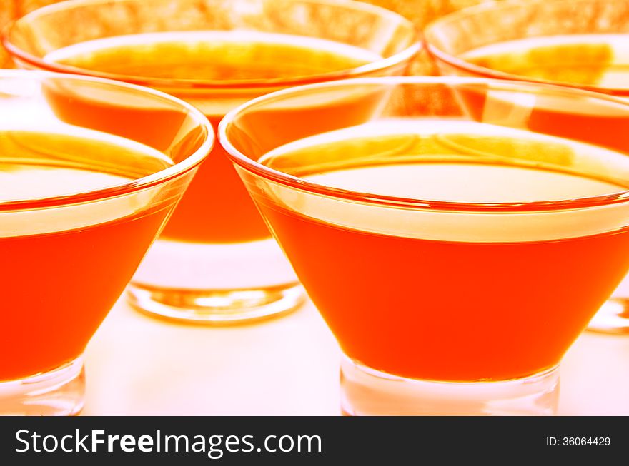 Orange jelly in glass pialas arranged on full background. horizontal image. Orange jelly in glass pialas arranged on full background. horizontal image