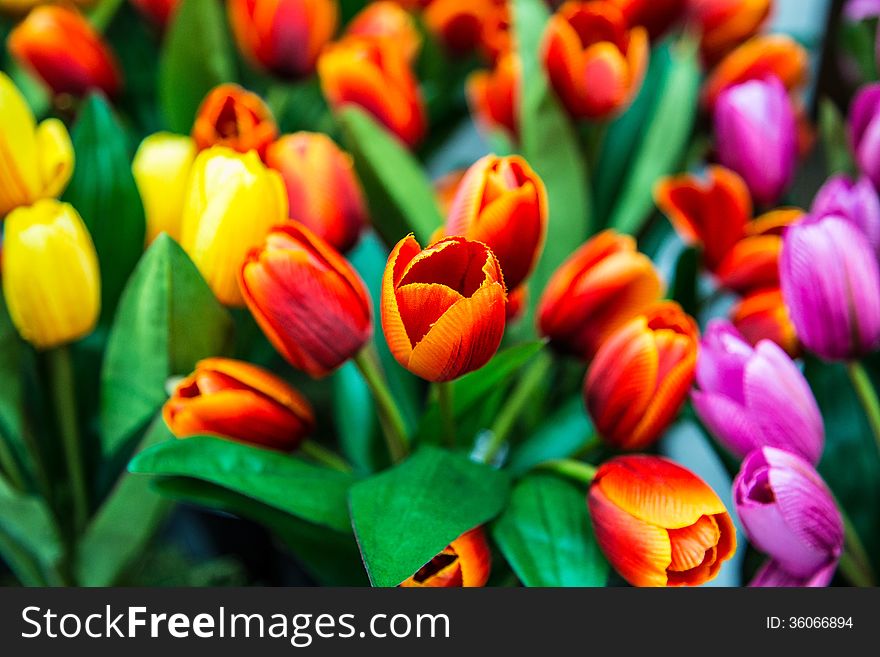 Beautiful and colorful artificial tulips are displayed for selling.