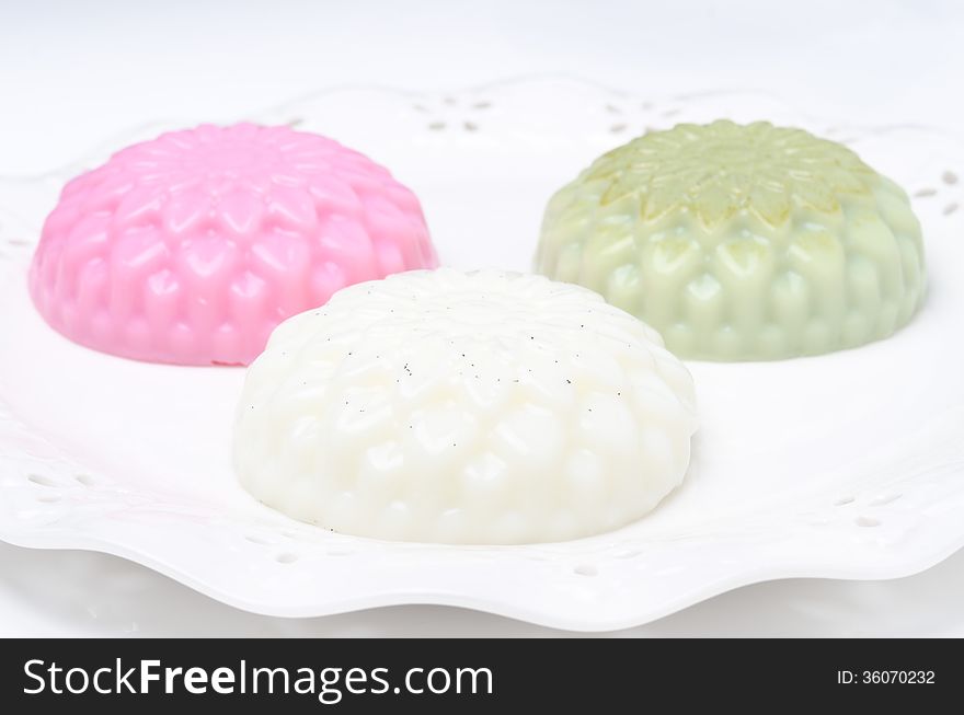 Different types of Panna cotta (raspberry, tea matcha, vanilla) on a plate horizontal closeup. Different types of Panna cotta (raspberry, tea matcha, vanilla) on a plate horizontal closeup