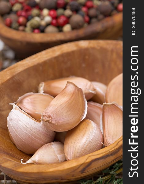 Garlic cloves in a bowl closeup, vertical