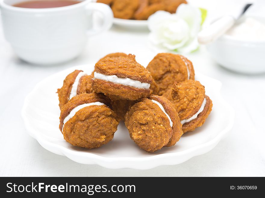 Pumpkin cookies with cream filling and tea, close-up