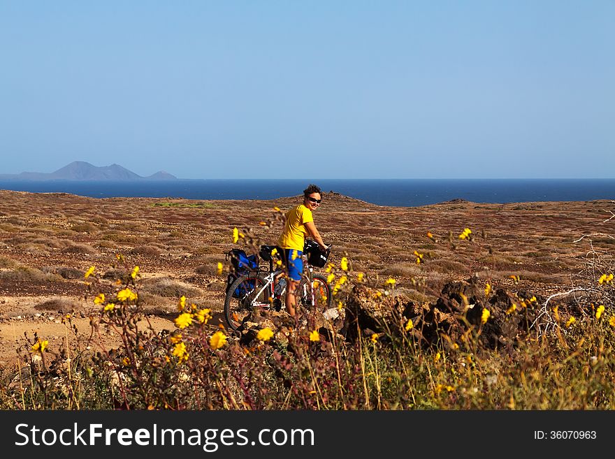 Woman in yellow riding bike on on Canary island. Woman in yellow riding bike on on Canary island