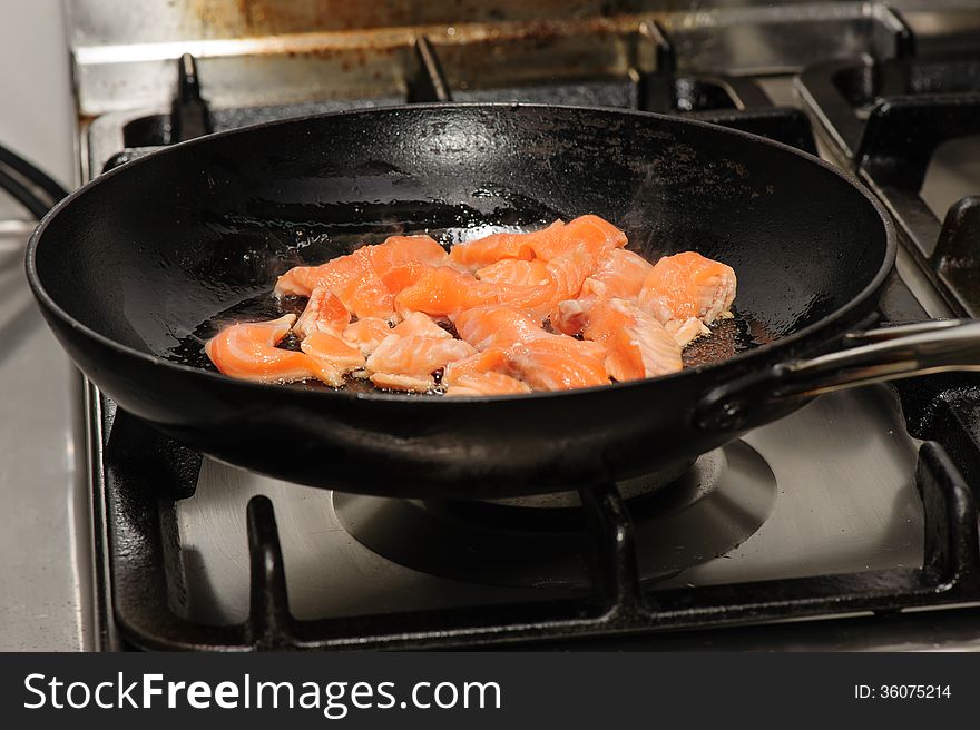 Pieces of red fish frying on oil in the pan. Pieces of red fish frying on oil in the pan