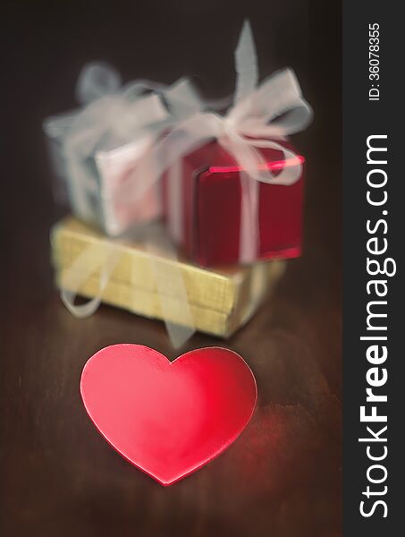 Decorative gift boxes and heart shaped object on wooden table. Decorative gift boxes and heart shaped object on wooden table