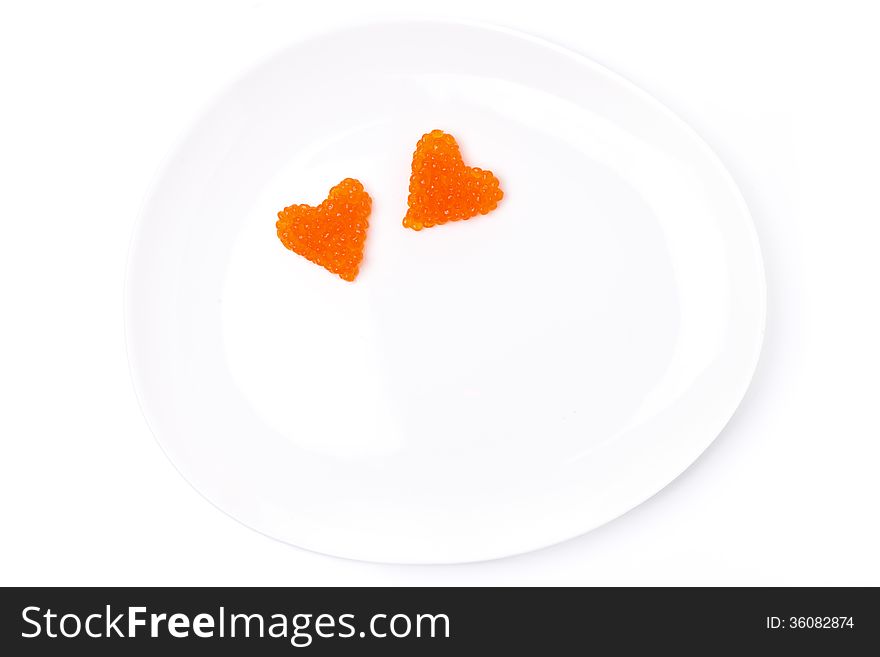 Two hearts of red caviar on a plate, isolated